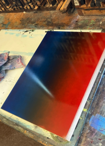 Photo of a board inked in a gradient from blue to red