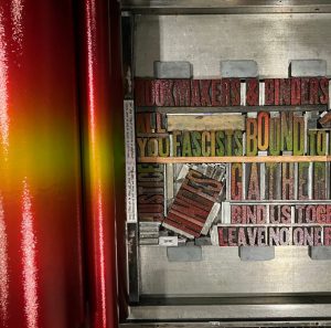 Photo of a press and wood type inked in a gradient from yellow to red