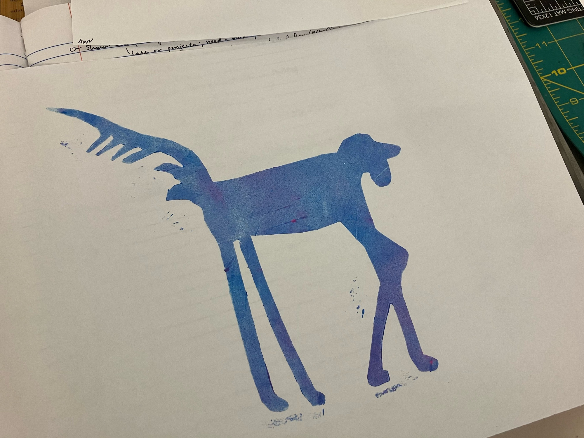 Photo of a white piece of paper printed with the shape of a dog with very very long legs, and inked with fluorescent blue and pink ink. 